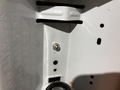 After removing the light bulb from this combination exhaust fan/light, the housing for the light can be removed by unscrewing this nut