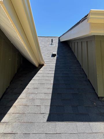 There is an exhaust duct vent visible in the roof above this downdraft range hood.