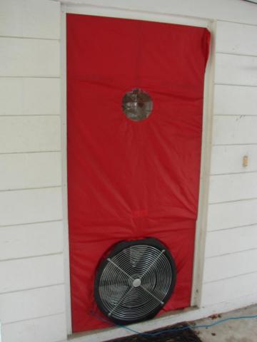 A blower door is installed in a doorway and is ready for testing