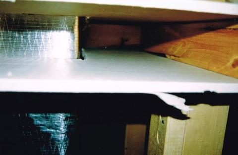 Cut-away view showing unsealed gaps around a heating duct that goes through a wall