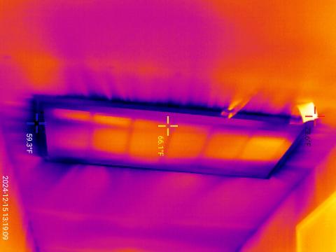 The dark streaks seen in this infrared camera image of a return vent in a ceiling indicate cooler air is leaking in around the vent.