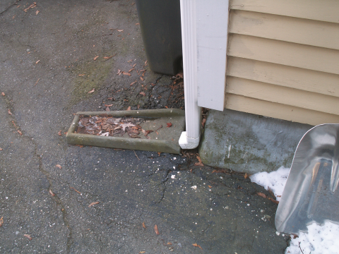 Wrong - This surface downspout run-out is directed toward the foundation instead of away from it.