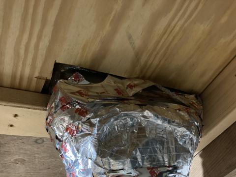 There are large, unsealed gaps where this HVAC duct penetrates the subfloor to supply a floor register; these gaps should be sealed with spray foam.