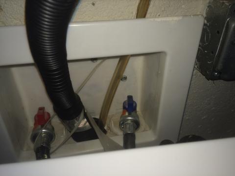 The condensate line (amber-colored plastic tube) from the high-efficiency furnace drains into the sewer via the same drain pipe as the clothes washer