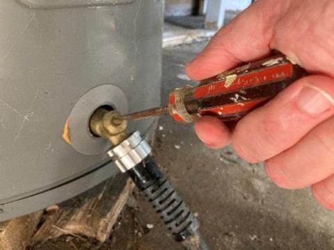 This water heater drain valve is operated using a flat-head screwdriver.