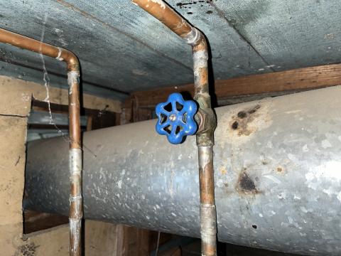 This cold-water inlet valve has a wheel-style handle. It is closed by turning the wheel clockwise.