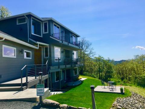 These wildfire-resistant decks have a solid decking surface, metal railings, and the underside timber supports are covered with flame-resistant fiber cement board; also the decking is set back from the vegetated slope. 