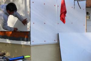 Contractor installs rigid foam while residing a house