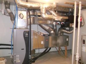 Right - An ultra-efficient (COP 5.7) ground source heat pump provides hot water to an air coil in the central air handler which uses a variable-speed electrically commutated fan motor to distribute conditioned air to the home’s ducts.