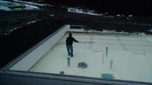 Between the ICF foundation walls, the builder sprayed closed-cell spray foam directly onto the gravel base to provide a vapor barrier and continuous layer of insulation under the slab. 