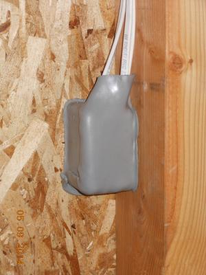 To minimize air leakage through electrical boxes, the boxes were either wrapped with fire-resistant putty (required at fire-rated walls) or wire penetrations were foamed and the boxes were caulked to the drywall.