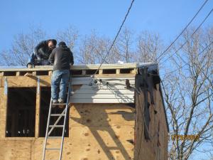 The existing 2x8 roof rafters were topped with OSB; two layers of 2-inch rigid foam; plywood; ice and water shield at rakes, eaves, and valleys; underlayment; and fiberglass shingles, plus 6 inches of open-cell foam under the decking.