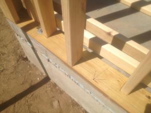 The 2x4 wall studs are staggered along the 2x6 sill plate providing space to weave insulation around each stud to stop thermal bridging through the wall.