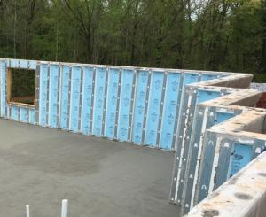 Right - Precast concrete basement walls come to the site with integrated rigid foam insulation and steel-faced concrete studs.
