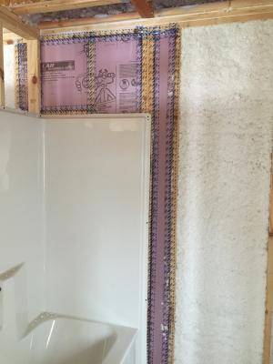 Moisture-resistant rigid foam insulation was installed to provide a continuous air and thermal barrier behind the tub-shower insert.  