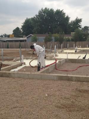 The builder’s crews spray foam directly onto the ground to provide a vapor barrier and insulation layer under the slab.