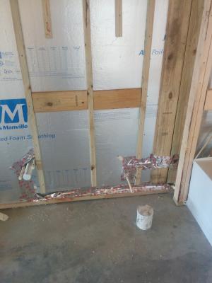The foam-filled concrete block walls are lined on the interior side with foil-faced rigid foam then topped with furring strips for attaching drywall. 
