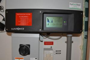 The photovoltaic system comes with a readout screen showing power production.