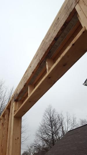 A layer of rigid foam is sandwiched between two layers of 2x8 lumber in this insulated header over a window.