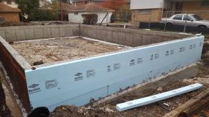 The basement walls are covered with a dimpled plastic water barrier then wrapped with 3 inches of XPS rigid foam with seams taped to keep out water. 