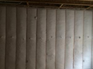 Dense-packed blown fiberglass insulation completely fills the wall cavities with no gaps or voids.