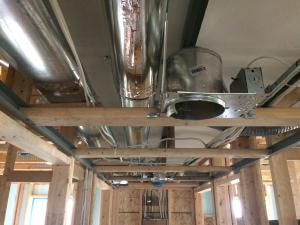 Right - Drywall is installed as an air barrier above the central hallway duct chase prior to installing the trunk ducts.