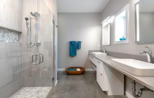This bathroom is handicapped accessible with a zero-entry shower and roll-up sinks.