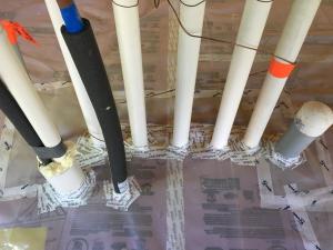 Plumbing penetrations through the below slab insulation are sealed with tape and spray foam.