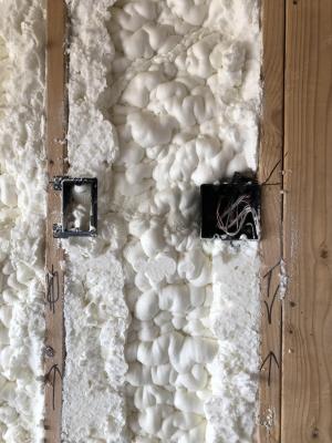 Right – Spray foam completely fills the wall cavities, providing a thorough layer of insulation behind electrical boxes.