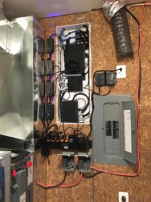 Right - The electronics for this home’s smart home system, including a Wi-Fi router, and controls for lighting, HVAC, security, energy production and tracking are housed together with the electrical panel and HVAC equipment in the home’s utility room.