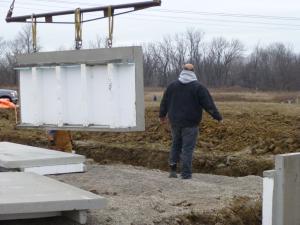 Right – Prepoured foundation panels with integrated insulation and vapor barrier are installed in place.