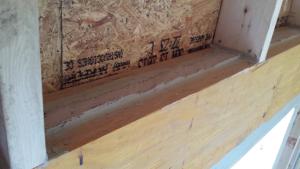 Right – A layer of sealant covers the wood-to-foam layer seams in the insulated header.