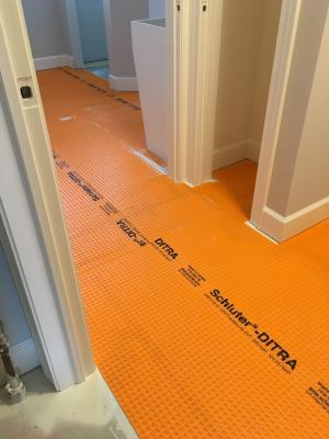 Right – A bond break layer is installed over the slab and under the floor tile.