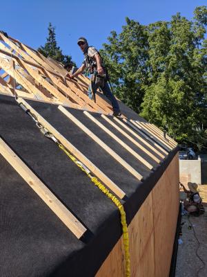 Weather resistant barrier is wrapped over the edge from roof to wall sheathing to provide a continuous air barrier at this transition.  