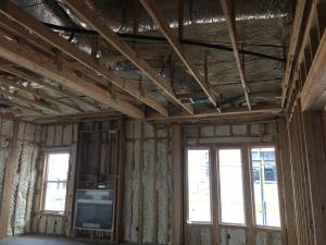 Right – Spray foam air seals and insulates the walls including the walls behind the fireplace and covers the underside of the roof deck of this mixed-dry climate home to provide an insulated attic space for HVAC ducts.