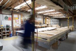 Right – Subfloors are installed in a clean, dry, well-lit factory setting for these modular, factory-built homes.