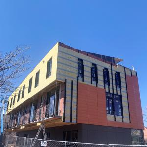 Right – Terra cotta tiles are attached to horizontal metal furring strips as the exterior cladding over mineral wool insulation on this multi-family building in Colorado. 