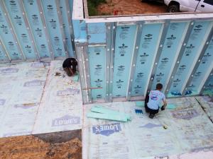 Right - Workers installed rigid foam on the floor and the sill plates of these pre-cast, pre-insulated concrete wall panels to provide a continuous layer of insulation under and around the not-yet-poured basement floor slab.