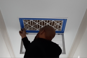 Right – An HVAC contractor installs a 4-inch-thick MERV 13 filter at the intake grille of this return air vent to prevent dust, allergens, smoke, and viruses from entering the duct system.