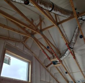 Right – R-23 of blown fiberglass fills the walls and unvented vaulted attic cavities of this marine-climate home while an additional R-20 (4-inches) of graphite-enhanced expanded polystyrene is installed above the roof sheathing.