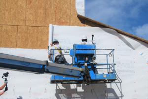 Right – House wrap is safely installed using a boom lift. 