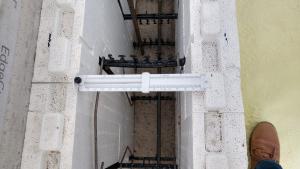 Right – Insulated concrete form (ICF) blocks are stacked like bricks, then rebar is set horizontally and vertically in the plastic spacers, then concrete is poured; the rigid foam and spacers stay in place to add support and thermal resistance to the wall