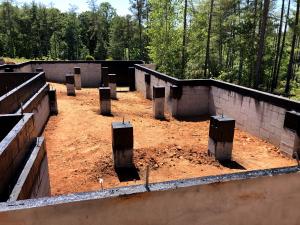 The top course of these concrete masonry unit (CMU) crawlspace foundation walls and piers is filled with grout then sprayed with a waterproofing membrane that acts as a capillary break and prevents moisture from migrating into the framing material.