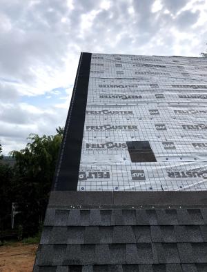 This roof was constructed to meet the IBHS Fortified Roof standard by sealing the decking seams with flashing tape, installing synthetic roof underlayment secured with metal drip edge and nailed every six inches, and using self-adhered starter shingles. 