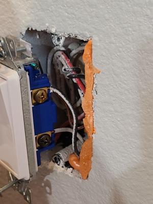 Air seal gaps between the electrical box and the drywall with caulk or low-expanding canned spray foam 