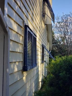 These aluminum Bahama shutters shade west-facing windows from afternoon sun and are approved for hurricane protection 