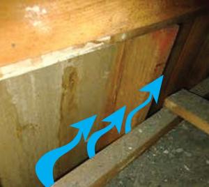 The stud cavities in this balloon-framed wall do not have blocking where the attic floor abuts it; this allows air to flow from inside the home to the attic above.