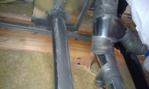 Sheet metal and mastic provide air sealing around a flue pipe. 