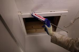 Caulk around the trim of the attic access panel or door to improve the air sealing between the living space and the attic.