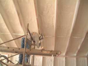 Right - A technician applies a thin layer of closed-cell foam to air-seal an unvented attic assembly before filling the ceiling joists with batt or blown insulation.